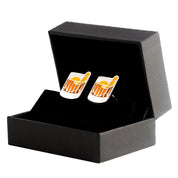 A pair of old-fashioned cocktail cuff links with a glass and garnish design, presented in a black box.