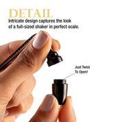 Close-up of a hand holding the opened small black cocktail shaker.