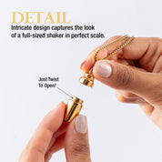 Close-up of a hand holding the opened small gold cocktail shaker.
