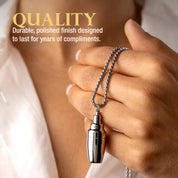 Hand holding the silver cocktail shaker necklace with text about quality and durability.