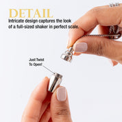 Close-up of a hand holding the opened small silver cocktail shaker.